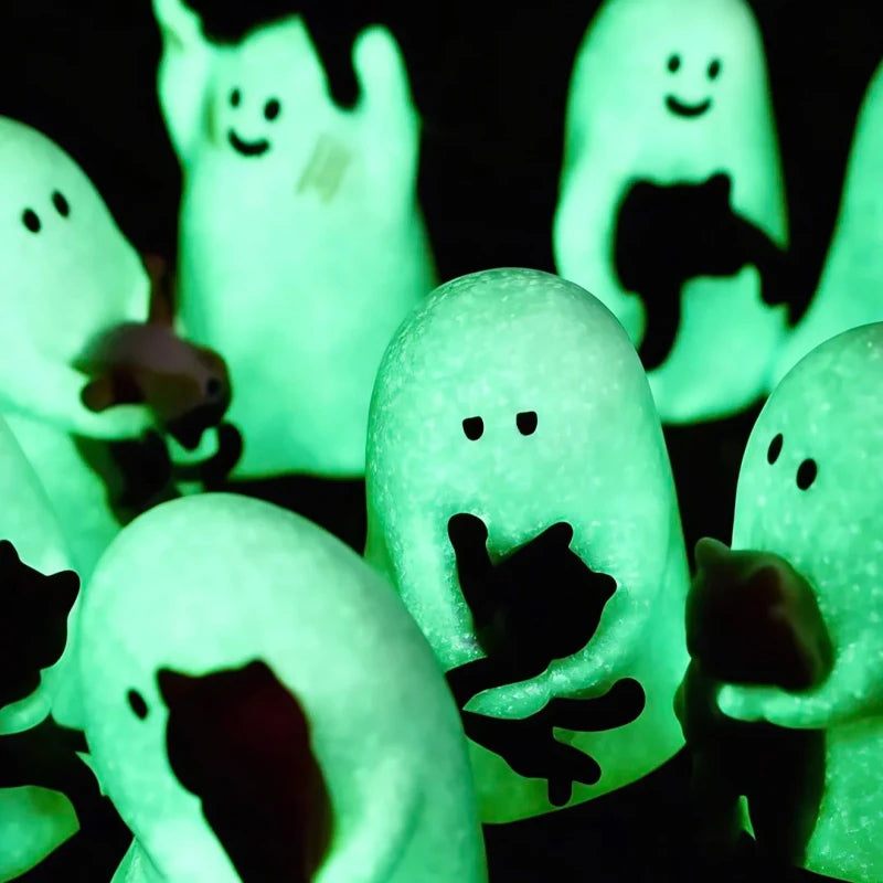 A collection of glowing green ghost figurines shaped like cats in a blind box display.