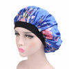 A woman wearing a blue satin hair bonnet with floral embroidery on a black headband.