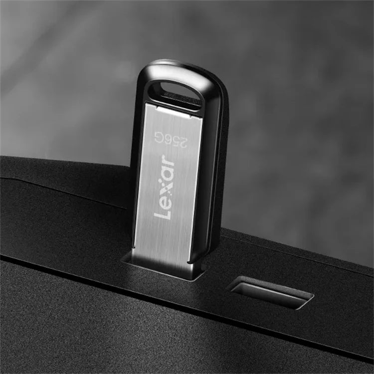 A close-up of a Lexar M400 USB 3.2 flash drive being inserted into a device slot.