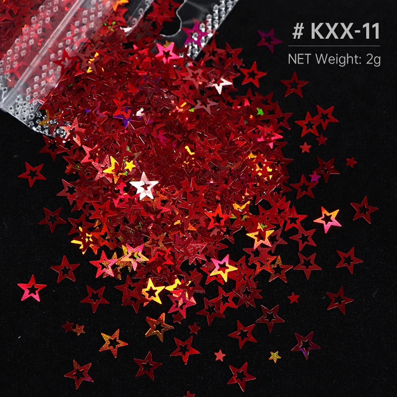 A pile of red and gold holographic star sequins scattered on a black surface.