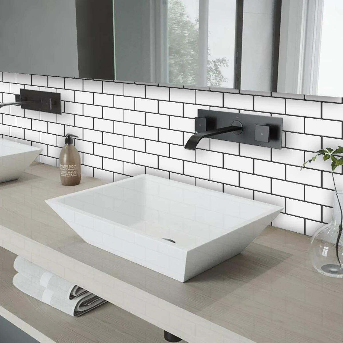 A modern white vessel sink installed on a light wood countertop with a subway tile backsplash and black faucet.