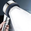 A hand is holding a high-pressure shower head, which is spraying a strong stream of water.