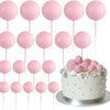 Eine Sammlung von 20 rosa Ball-Kekstoppern auf rosa Stäbchen.