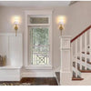 A hallway features a white built-in shelf with a window and two wall sconces illuminating the area.