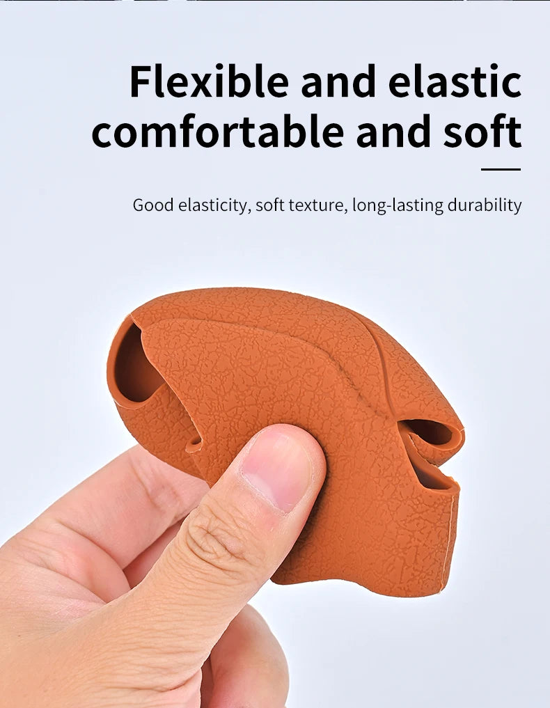 A hand is holding an orange silicone gear shift cover, demonstrating its flexible and soft texture.