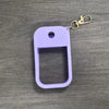 A purple silicone protective case for a hand sanitizer spray attached to a metal keyring.