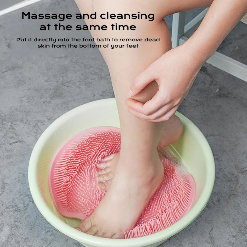 A person is using a pink suction cup foot massage mat to cleanse and massage their feet in a bowl.