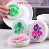 Ten pieces of random colored eco-friendly wood pulp dish sponges are displayed on a white plate.
