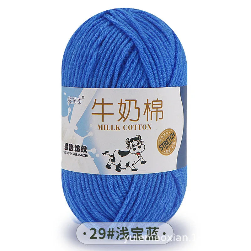 A ball of blue milk cotton blend yarn with a label featuring a dog and text in Chinese and English.