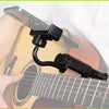 An adjustable black phone mount is attached to the neck of an acoustic guitar for hands-free viewing.