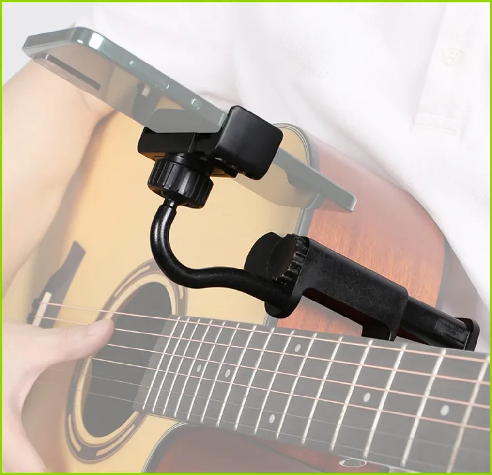 An adjustable black phone mount is attached to the neck of an acoustic guitar for hands-free viewing.