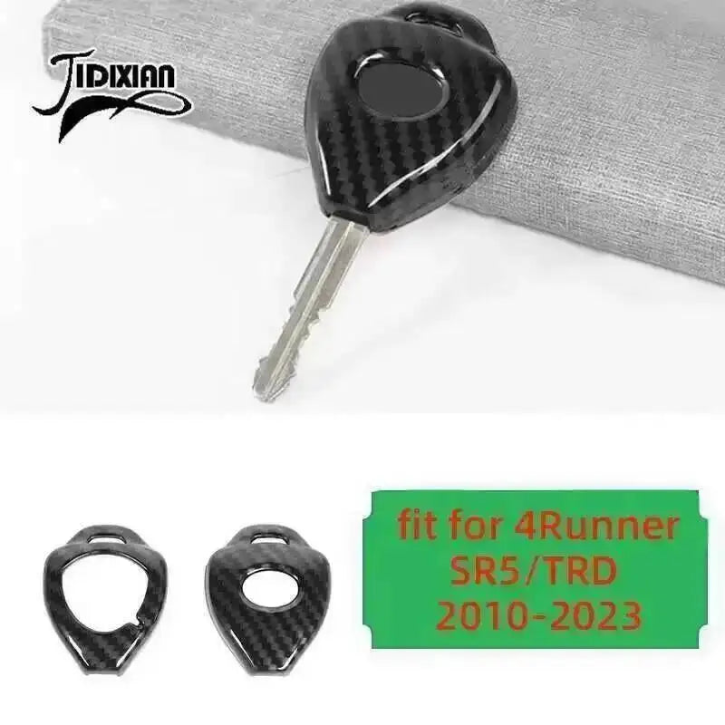 A black carbon fiber trim kit for a Toyota 4Runner, shown with a key and an oval piece.