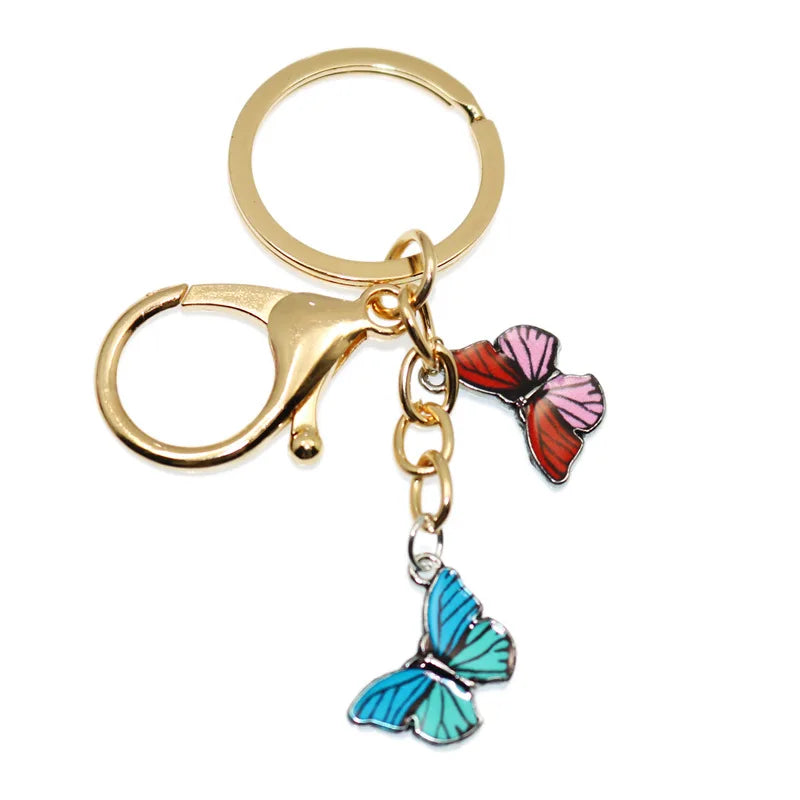 Gold-toned butterfly keychain charm with pink and blue accents