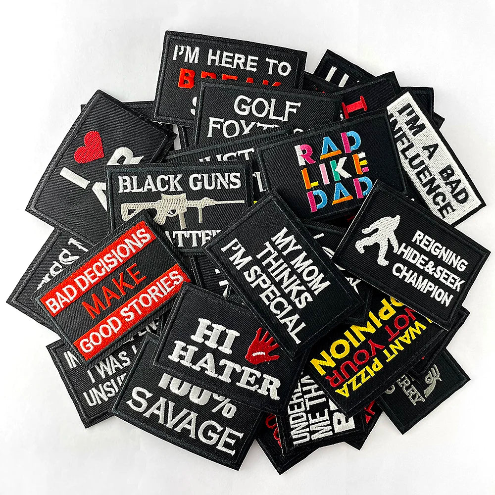 A collection of black embroidered iron-on patches with various funny text designs like I'm here to break and bad decisions ma