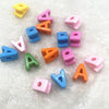 A collection of 10 mixed alphabet letter beads in various colors and shapes scattered on a white surface.