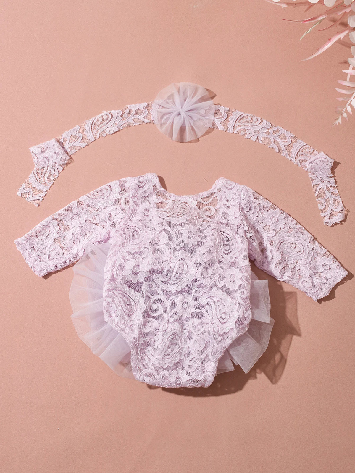 A delicate pink lace newborn princess tutu dress romper with a matching headband displayed on a neutral background.