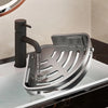 A silver corner shower caddy with a mounted shower head is shown on a glass surface.