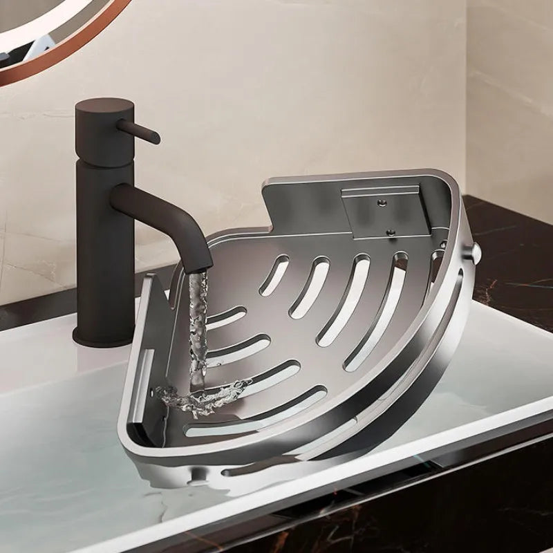 A silver corner shower caddy with a mounted shower head is shown on a glass surface.