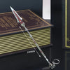 A detailed metal sword keychain with a sharp point and decorative hilt rests on a stack of books.