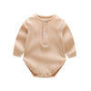 A beige ribbed long-sleeved cotton romper for a baby girl