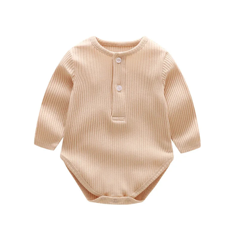 A beige ribbed long-sleeved cotton romper for a baby girl