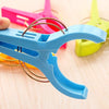 A blue heavy-duty laundry clip is shown against a light wooden background, with other colored clips visible in the blurred ba