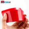 A hand is holding a bright red car windshield ice scraper and squeegee tool.
