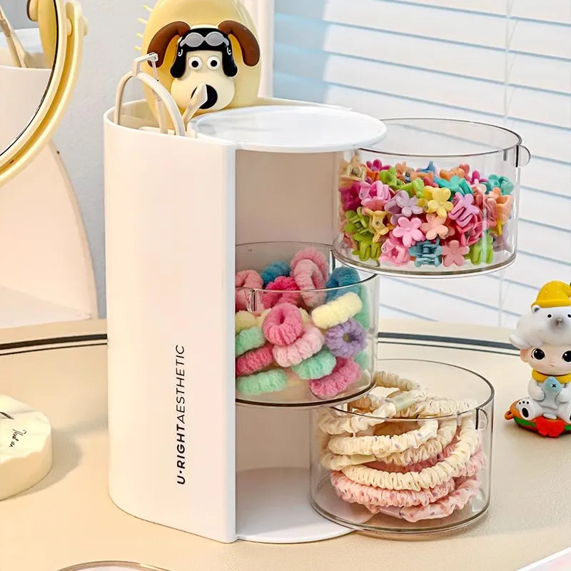 A white acrylic organizer holds various colorful hair accessories and a yellow stuffed animal.