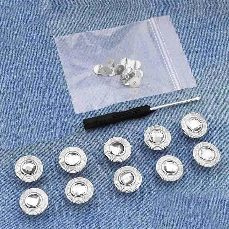 A collection of silver instant no-sew snap buttons laid out on a translucent plastic sheet.