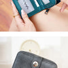 A teal vintage RFID blocking short wallet with a zipper closure is held by a person.