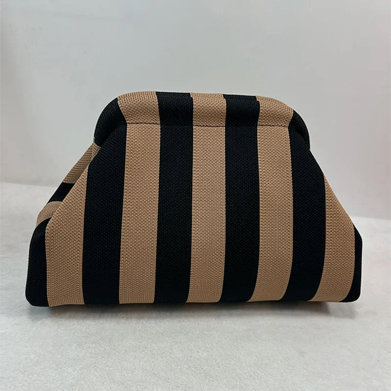 Clutch de tejido con rayas verticales negras y beige.