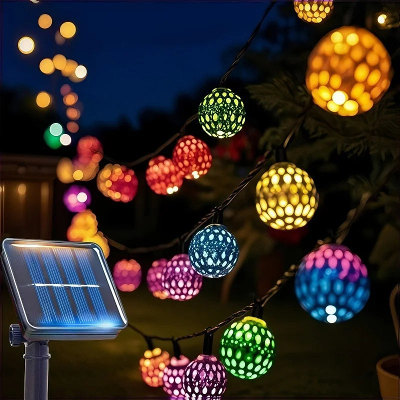 String lights featuring Moroccan-style glowing orbs illuminating an outdoor scene at night.