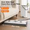 A white flat mop and bucket set with a long handle is shown next to a beige sofa, demonstrating its wide coverage.