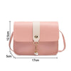 A light pink compact crossbody handbag with a beige adjustable strap and gold chain detail.