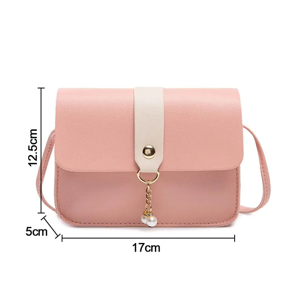 A light pink compact crossbody handbag with a beige adjustable strap and gold chain detail.