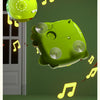 A green dinosaur bubble machine floats in the air with musical notes surrounding it.