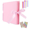 Pink scrapbook album with loose-leaf pages and a pink ribbon bow, next to colorful striped paper.