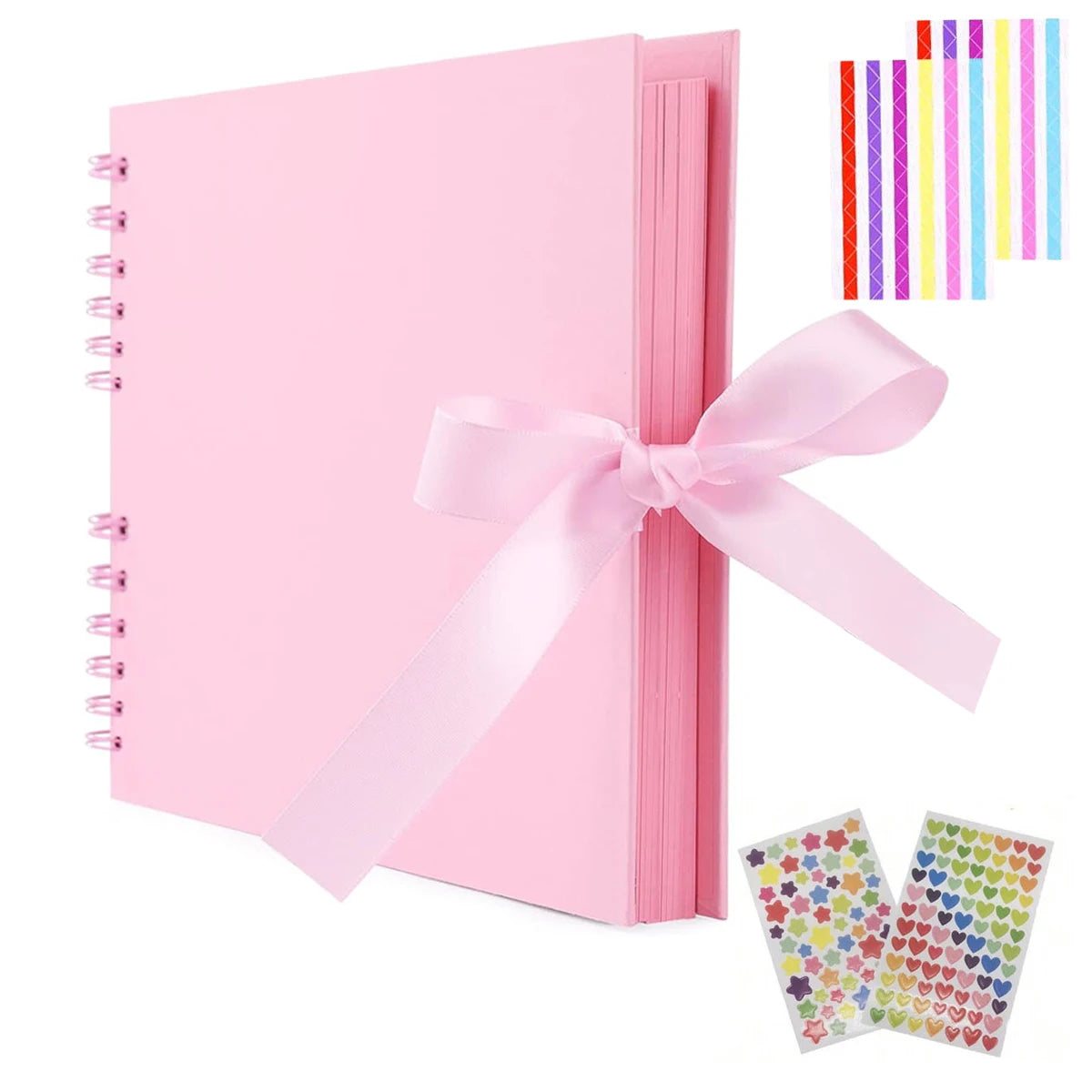 Pink scrapbook album with loose-leaf pages and a pink ribbon bow, next to colorful striped paper.