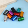 A set of four colored bullet shell tire valve stem caps displayed on a light blue surface.