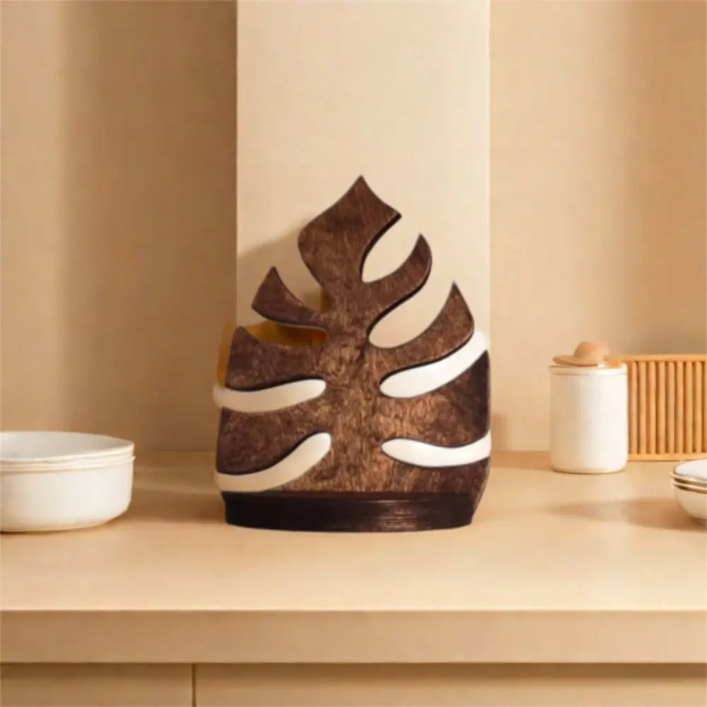 A rustic wooden wall-mounted storage rack with plant decor featuring a stylized leaf shape in brown and white.