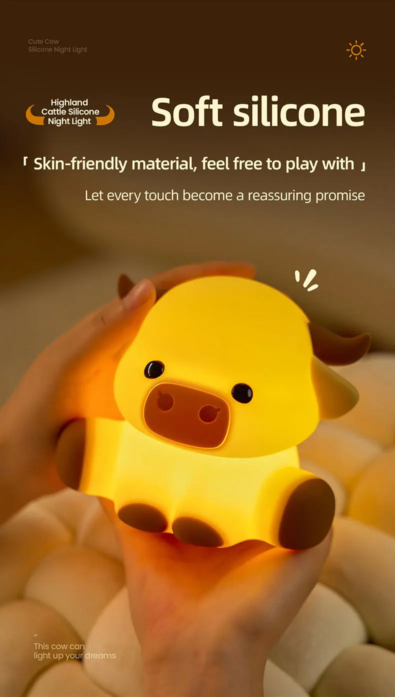 A hand holds a yellow silicone cow night light illuminating the face and body.
