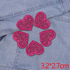 Five pink glitter heart iron-on embroidered patches arranged in a circle on a denim fabric.