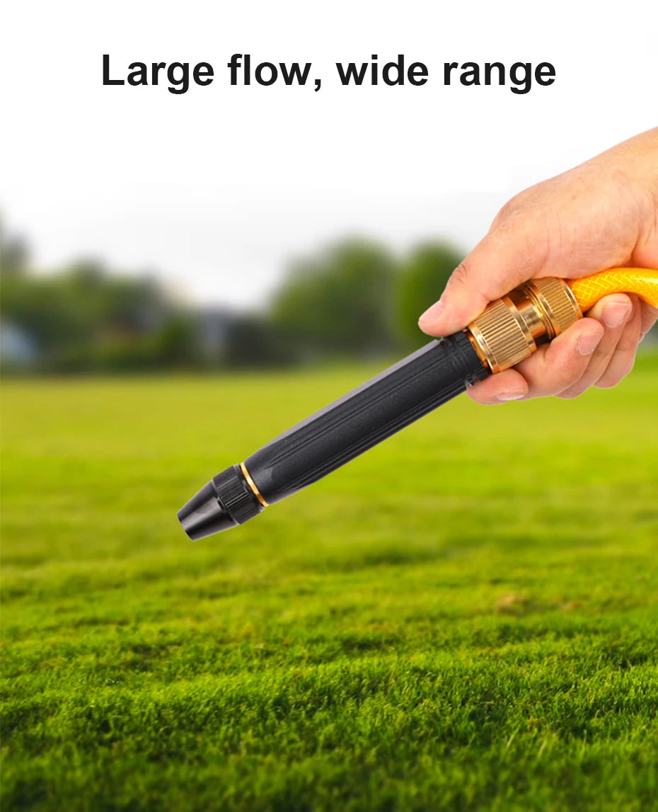 A hand holds a black and gold high-pressure water gun, demonstrating its large flow and wide range capability on green grass.
