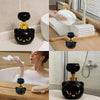 A black cat paw shaped foam soap dispenser is shown in various contexts, including on a counter and near a sink.