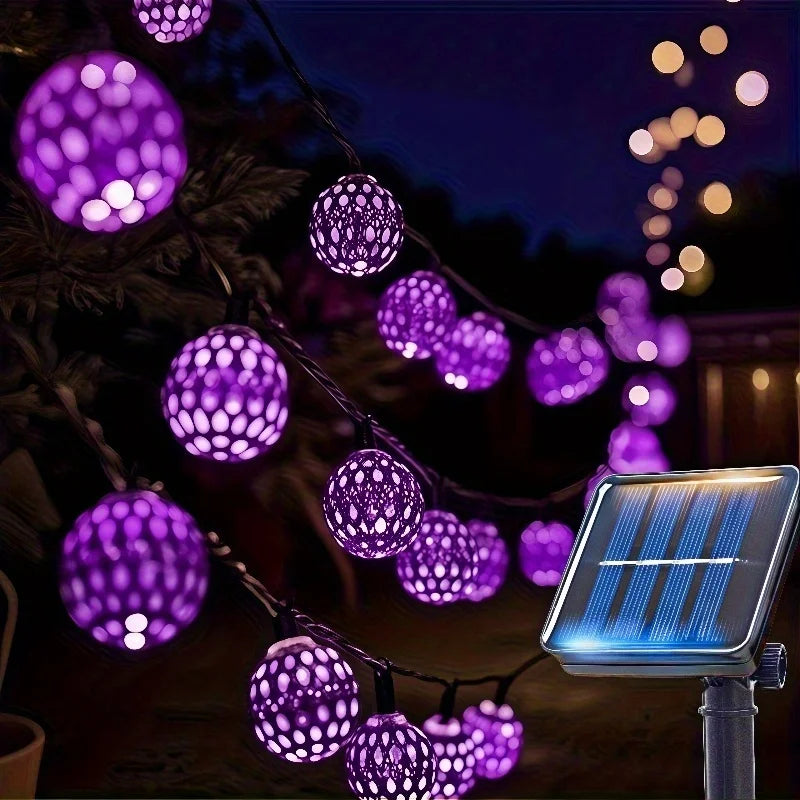 String lights featuring purple Moroccan-style glowing orbs and a solar panel setup at night