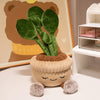 A cute plush doll shaped like a plant with soft green leaves and fuzzy accents.