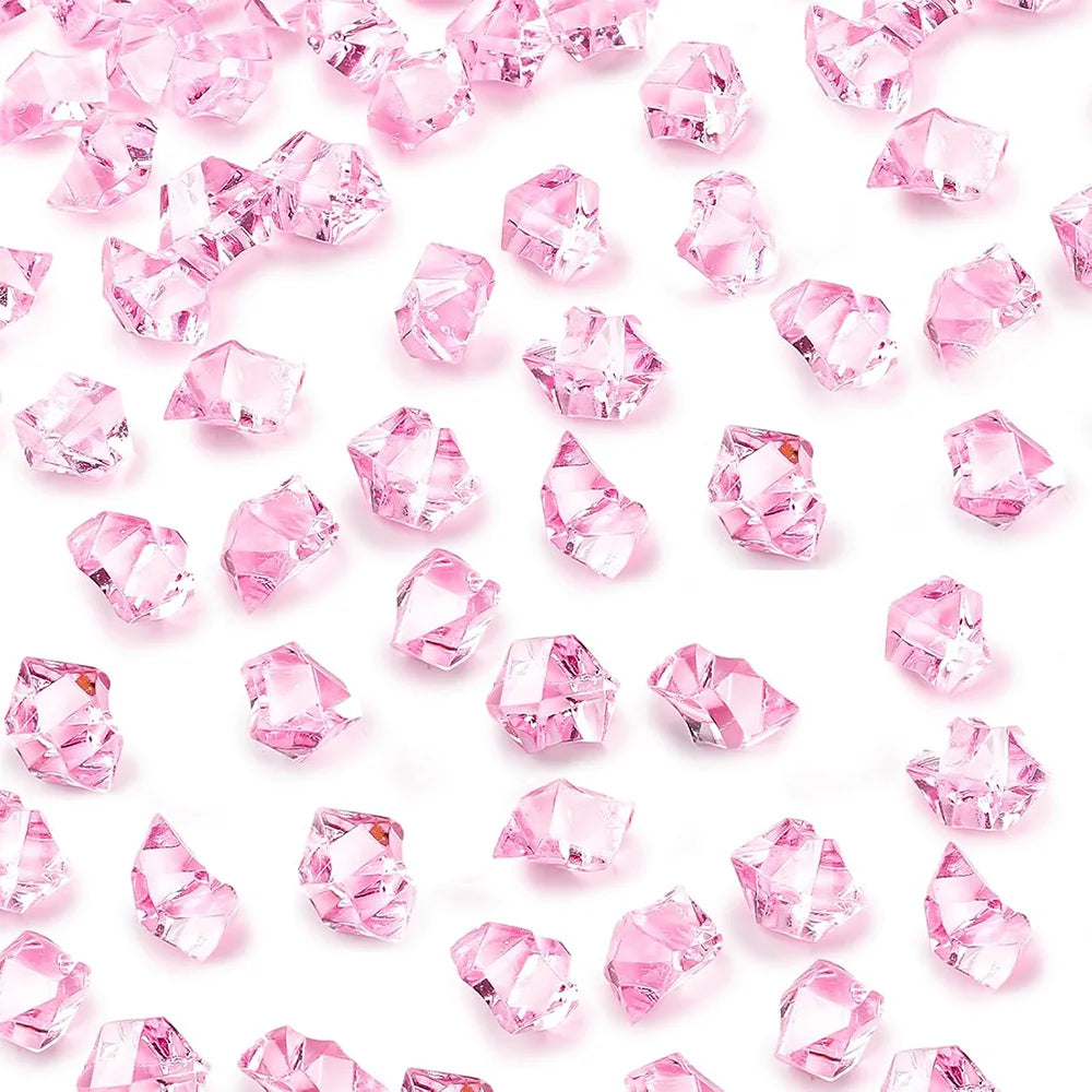 Pink acrylic crushed ice gems scattered on a white background for vase fillers and decor