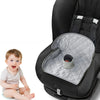 A baby sitting in a black seat with a gray quilted pad and an orange-colored item inside.