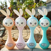 Four musical rabbit baby rattle and teether toys in peach, pink, light blue, and turquoise colors