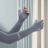 Gray sports arm sleeves being worn on an arm against a light gray curtain backdrop.